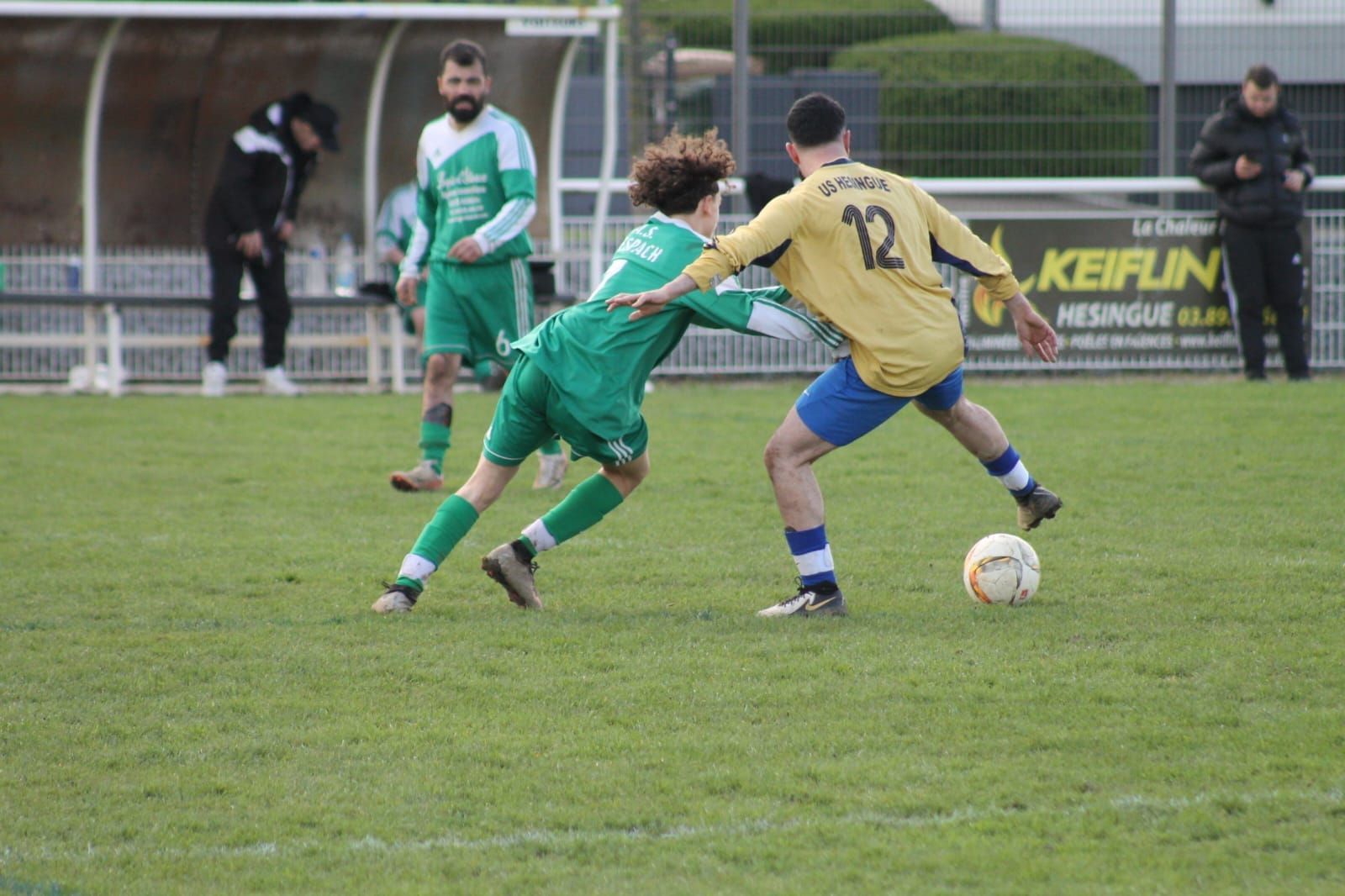 Un groupe de joueurs de football en uniformes verts sont assis par terre