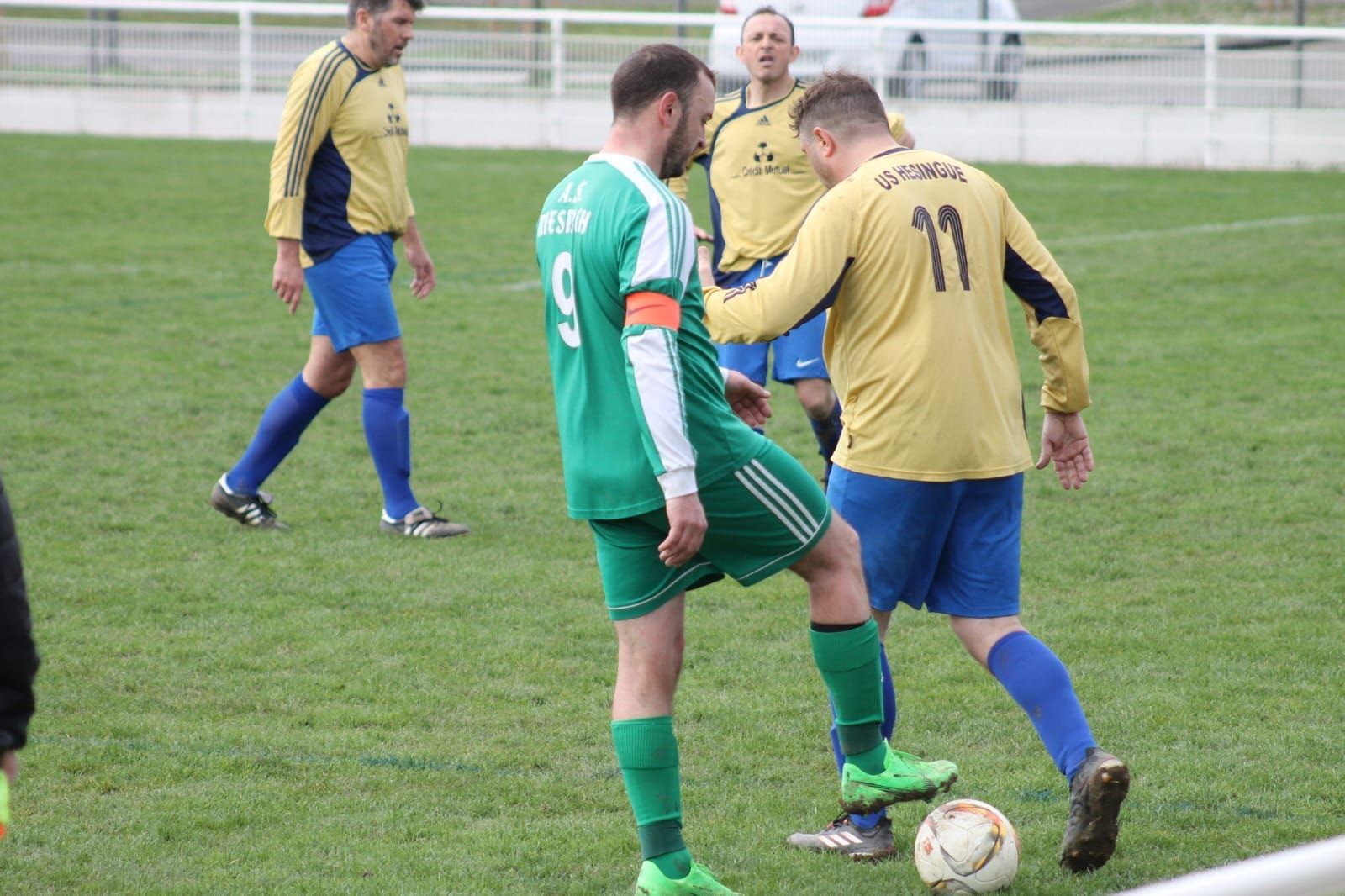 Un groupe d'hommes jouent au football sur un terrain.