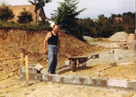 Un homme debout à côté d'une brouette sur un chantier de construction