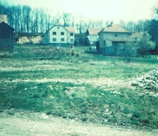 Une photo en noir et blanc d'une maison au milieu d'un champ.