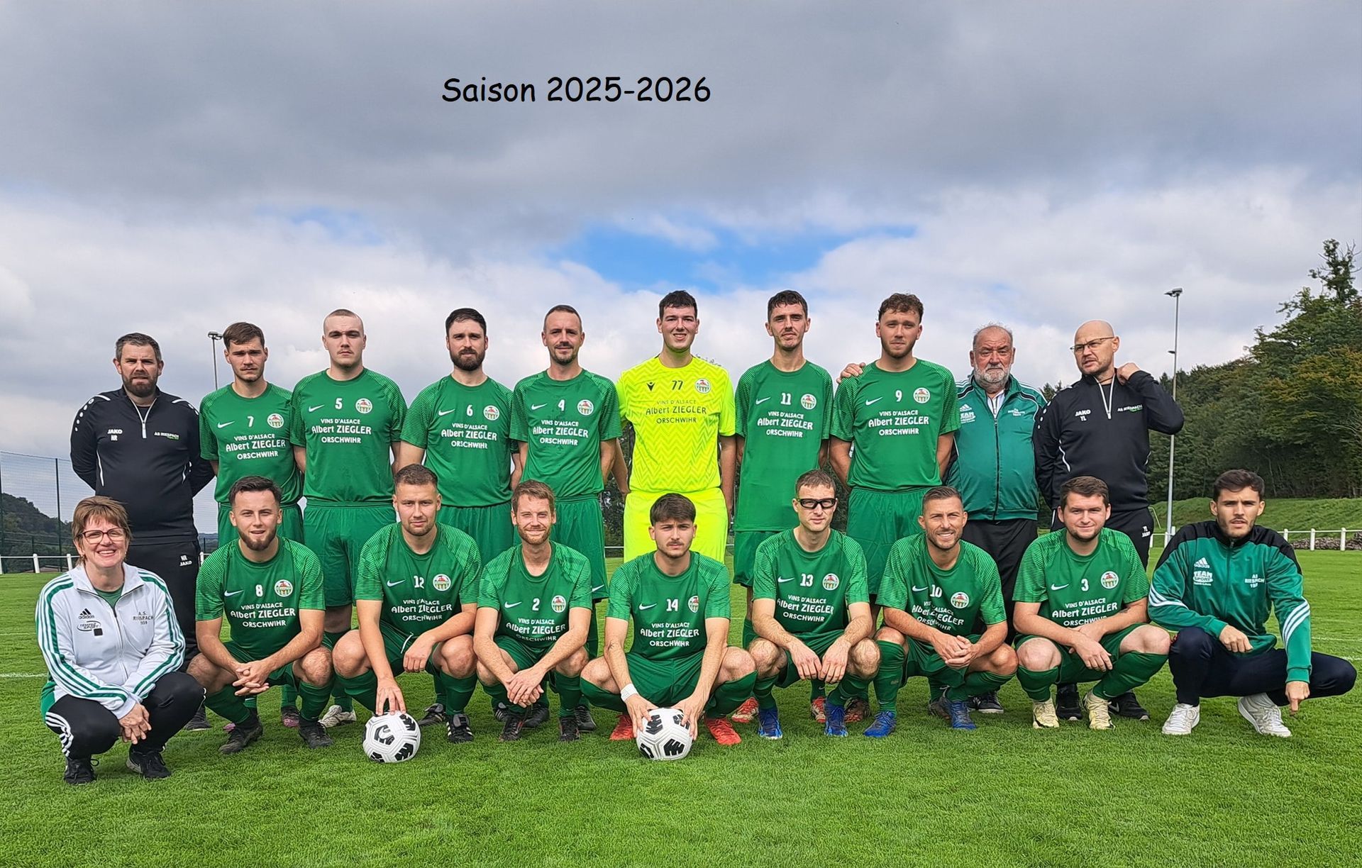 Une équipe de football pose pour une photo sur un terrain.