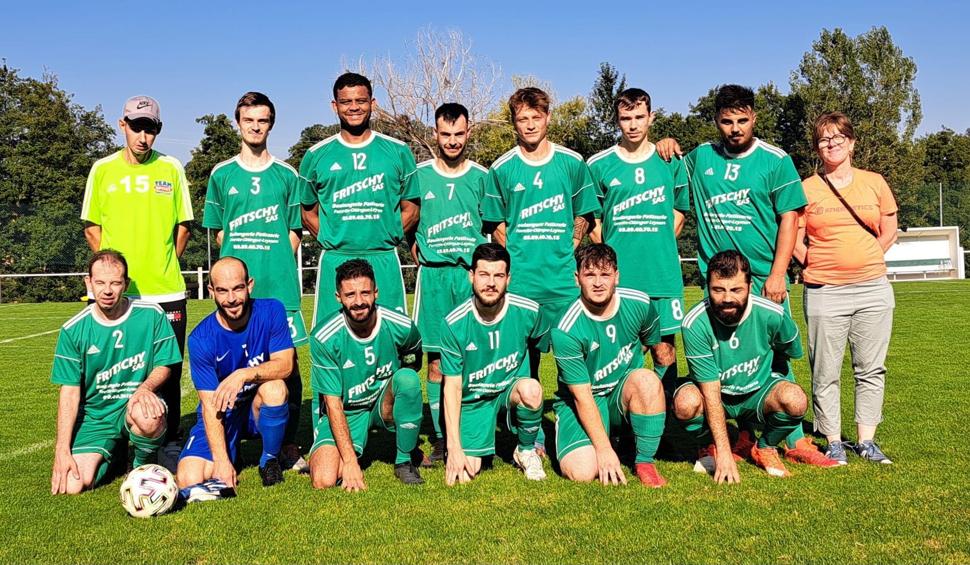 Une équipe de football pose pour une photo sur un terrain.