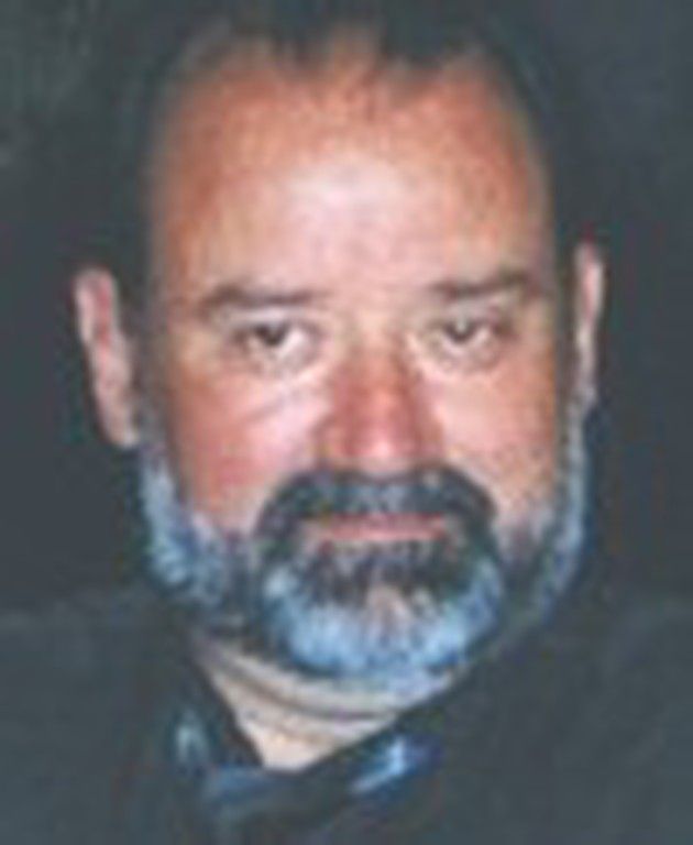 Un homme avec une barbe porte un foulard autour du cou.