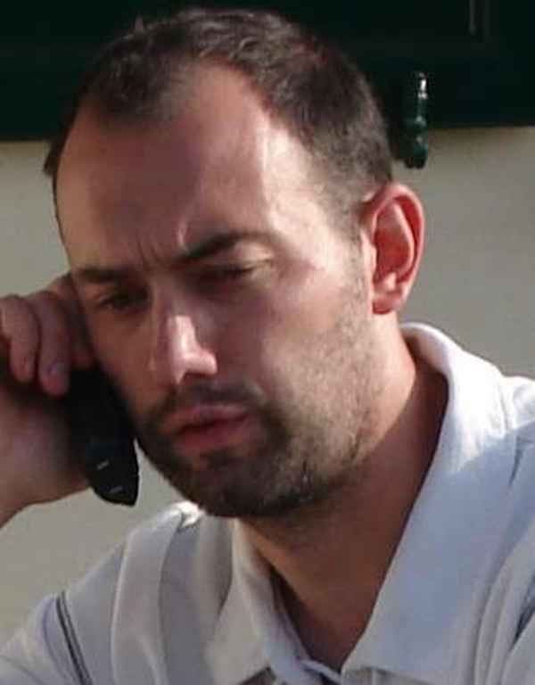 Un homme avec une barbe parle au téléphone portable.