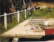 Un groupe de personnes travaille sur une plate-forme en bois dans un champ.