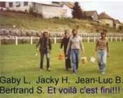 Un groupe de personnes debout au sommet d'un champ vert luxuriant.