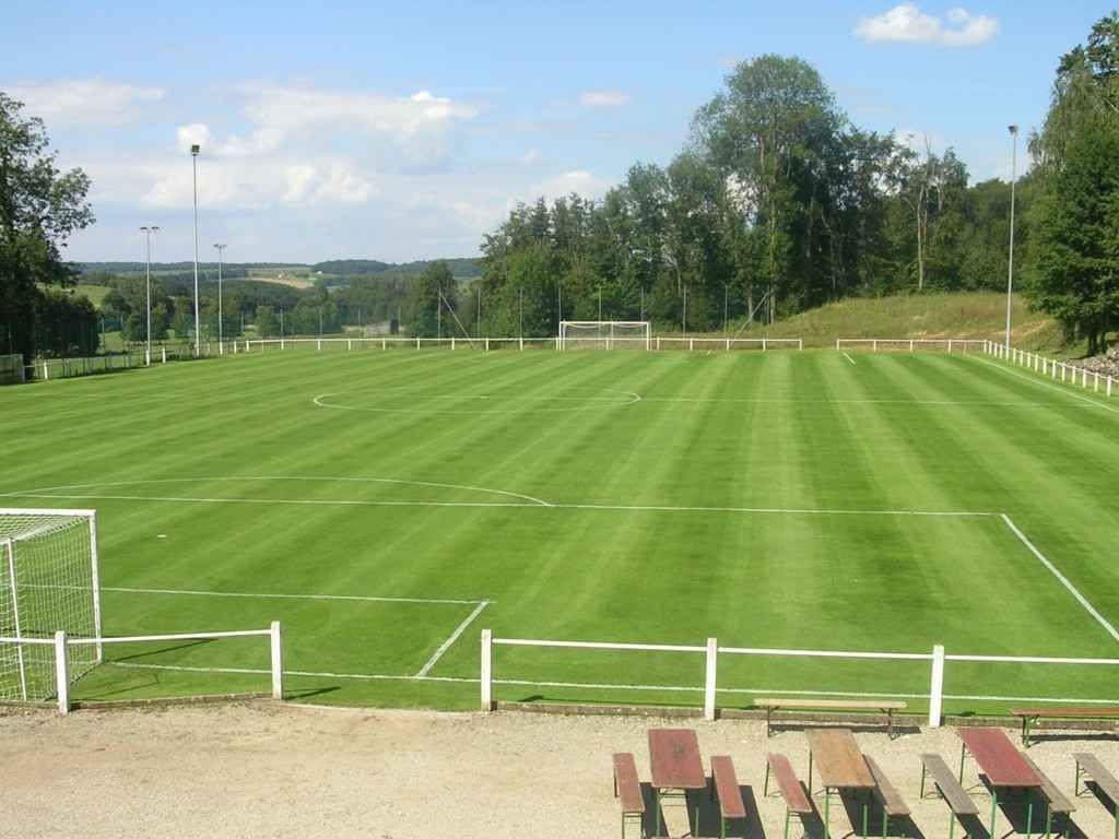 Un terrain de football avec des tables et des bancs au premier plan