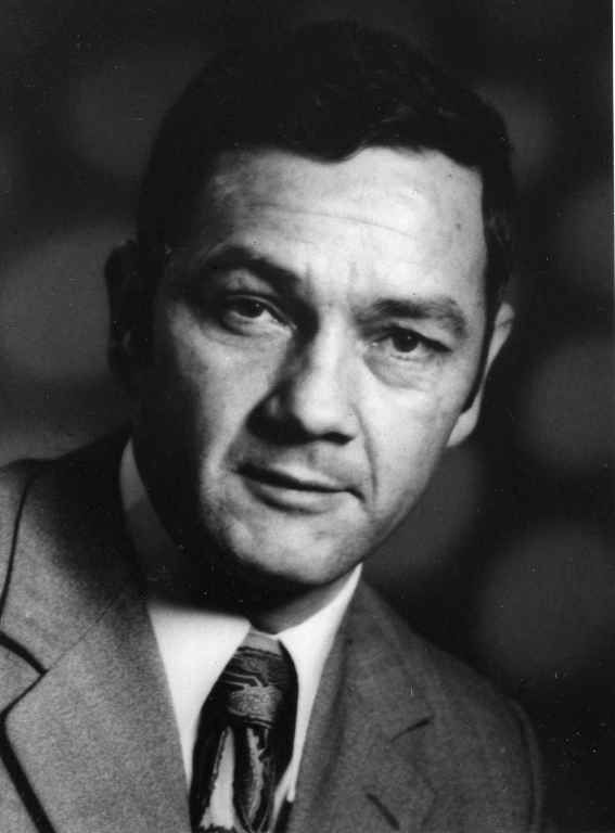 Une photo en noir et blanc d'un homme en costume et cravate.