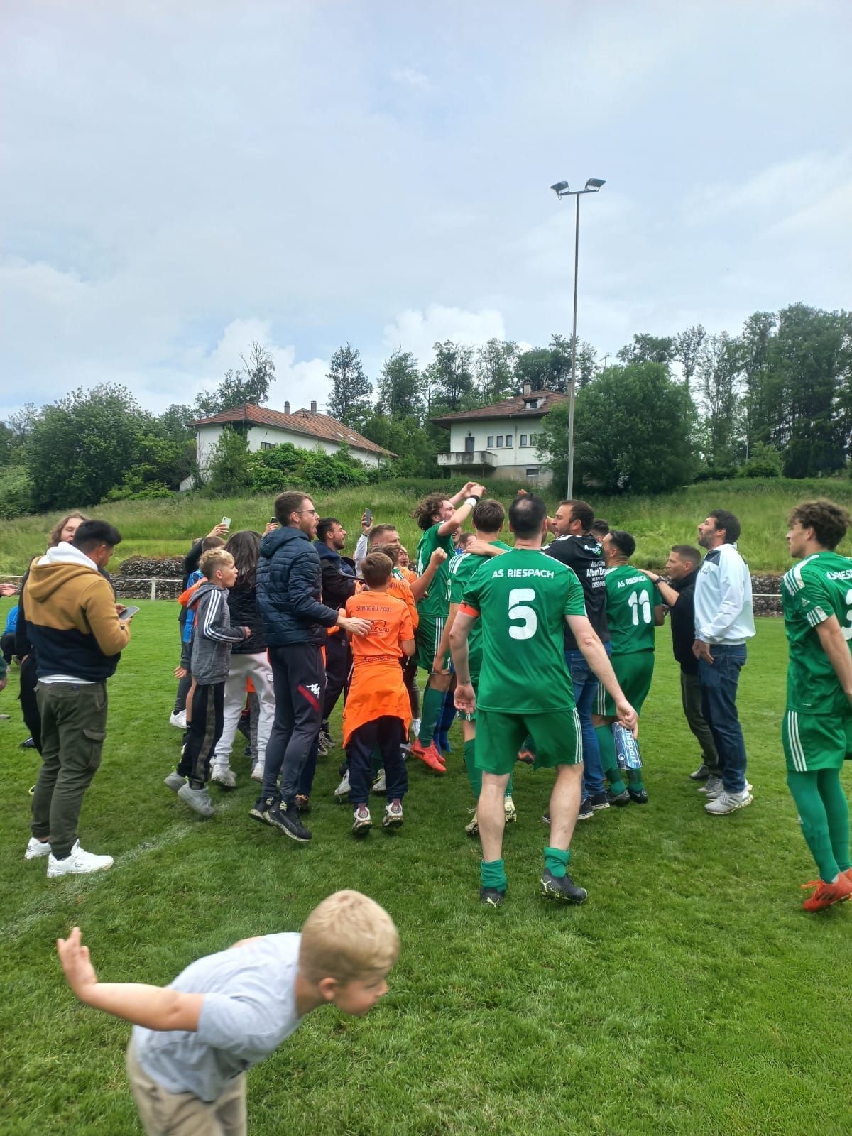 Un groupe de personnes se tient debout sur un terrain de football.