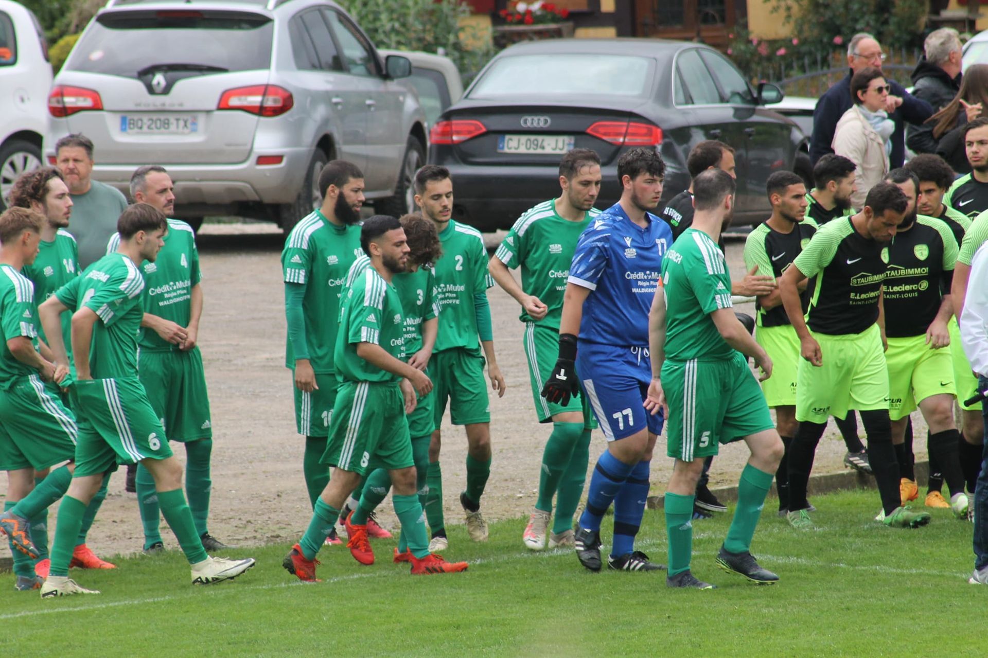 Un groupe de joueurs de football marche sur un terrain.