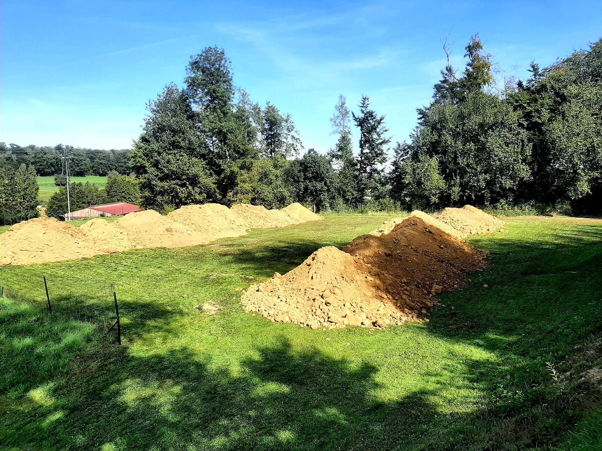 Un gros tas de terre repose sur un champ vert luxuriant.