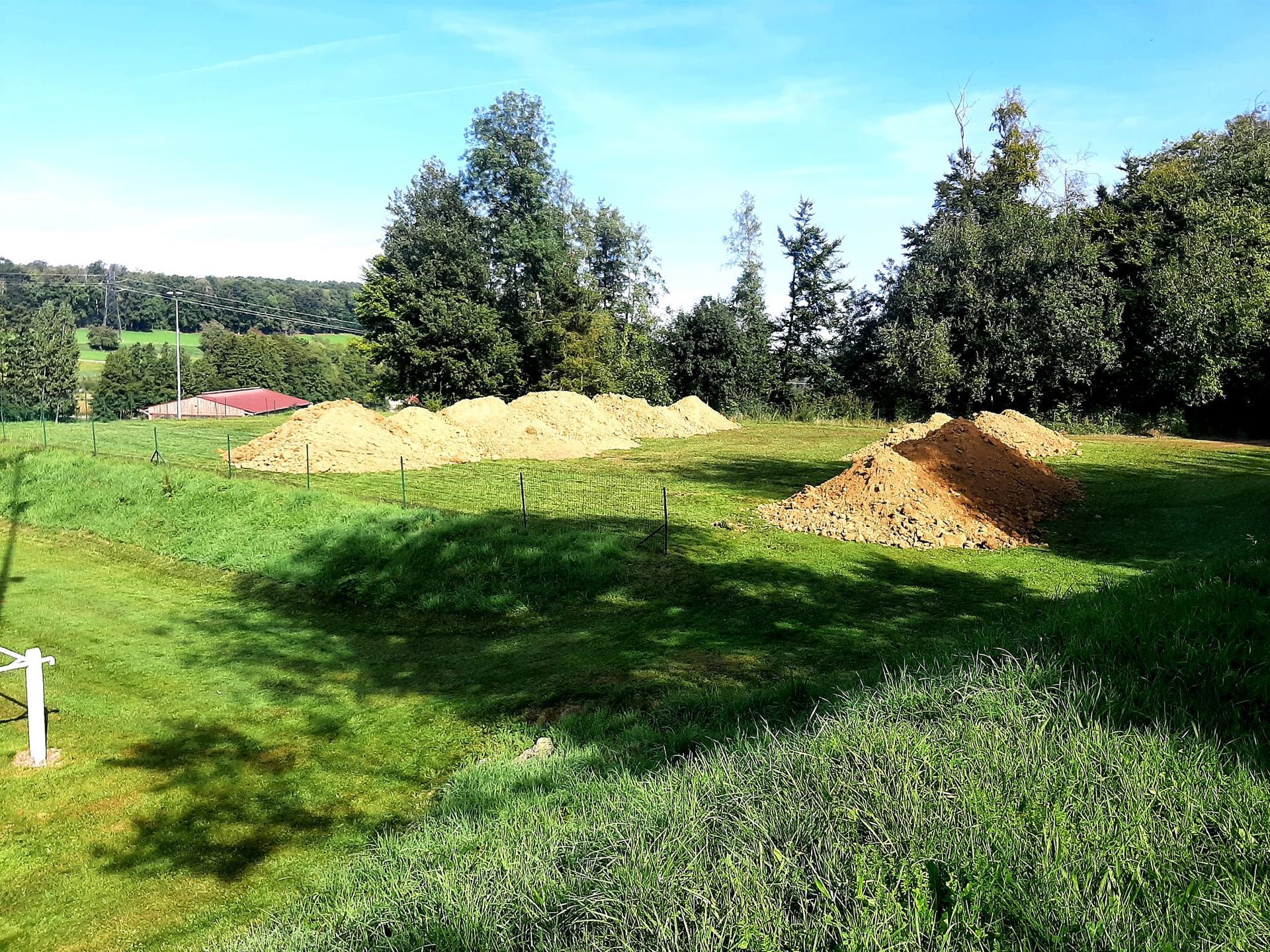Un grand champ herbeux avec un tas de terre au milieu.