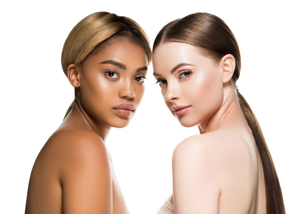 Women Are Posing for A Picture in Front of A Christmas Tree — Skin Exquisite Laser & Cosmetic Clinic in Port Macquarie, NSW