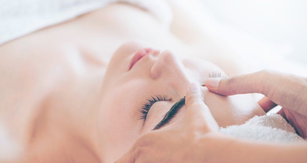 A Woman Is Getting a Facial Massage — Skin Exquisite Laser & Cosmetic Clinic in Port Macquarie, NSW