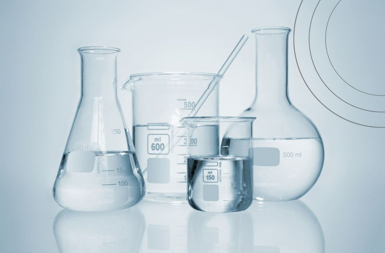 A Group of Beakers Filled with Liquid on A Table — Skin Exquisite Laser & Cosmetic Clinic in Port Macquarie, NSW