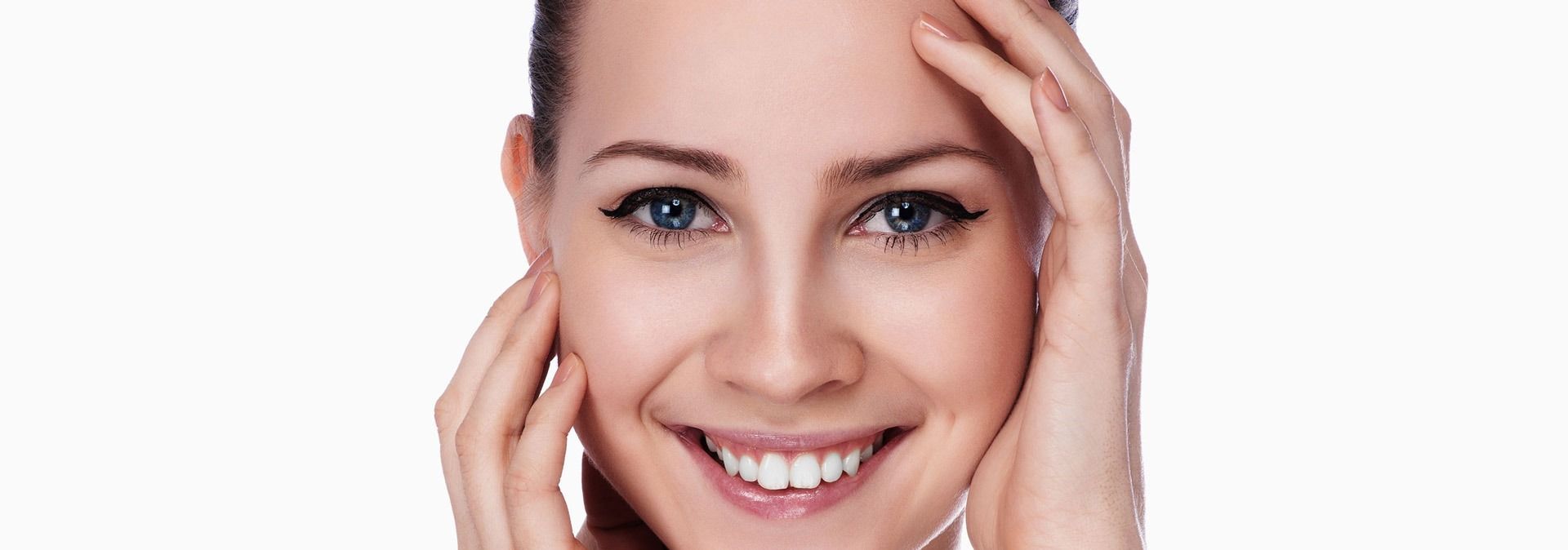 A Woman Is Smiling and Touching Her Face with Her Hands — Skin Exquisite Laser & Cosmetic Clinic in Port Macquarie, NSW