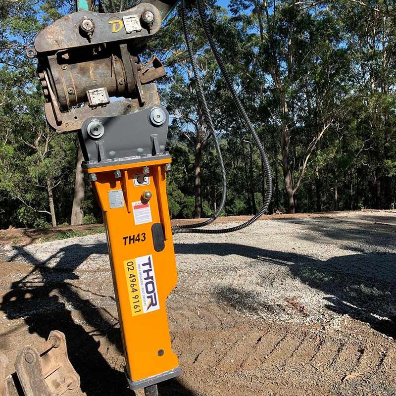 A Yellow Thor Hammer Is Sitting On Top Of A Dirt Road — Atholyn Earthmovers in Cessnock, NSW