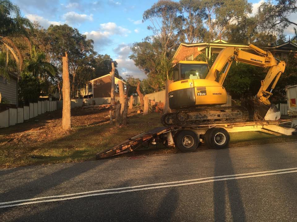 A Yellow Excavator Is On A Trailer On The Side Of The Road — Atholyn Earthmovers in Maitland, NSW