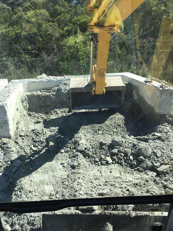 A Yellow Excavator Is Digging A Hole In The Ground — Atholyn Earthmovers in Maitland, NSW