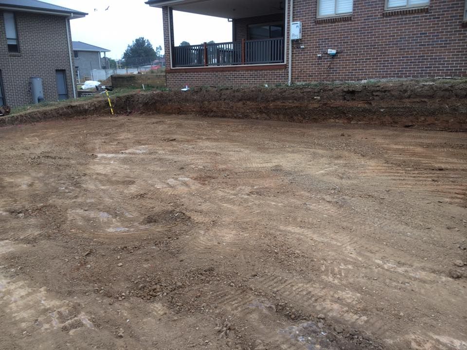 A Large Pile Of Dirt In Front Of A Brick House — Atholyn Earthmovers in Branxton, NSW
