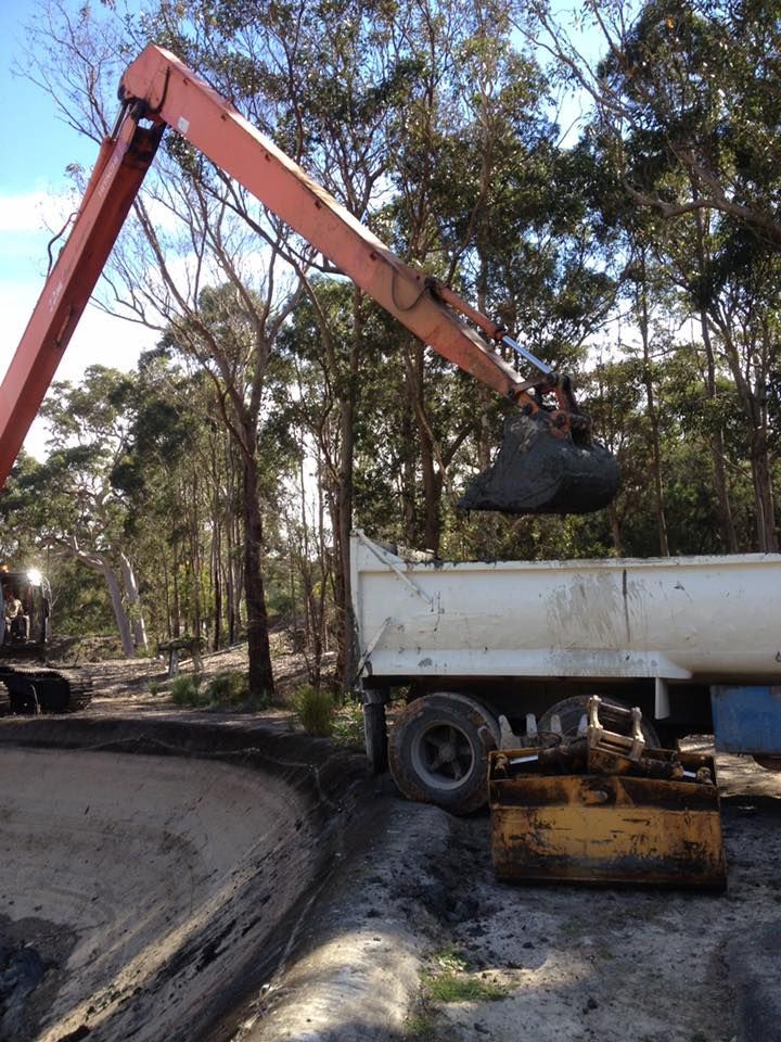 A Crane Is Loading Dirt Into A Dump Truck — Atholyn Earthmovers in Branxton, NSW