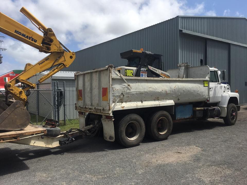 A Komatsu Excavator Is Attached To A Dump Truck — Atholyn Earthmovers in Cessnock, NSW