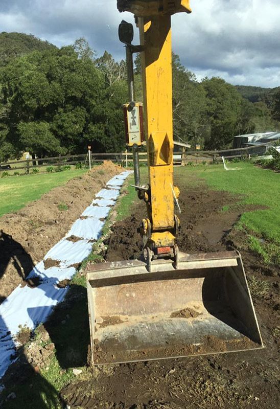 A Yellow Excavator Bucket Digging The Land — Atholyn Earthmovers in Cessnock, NSW