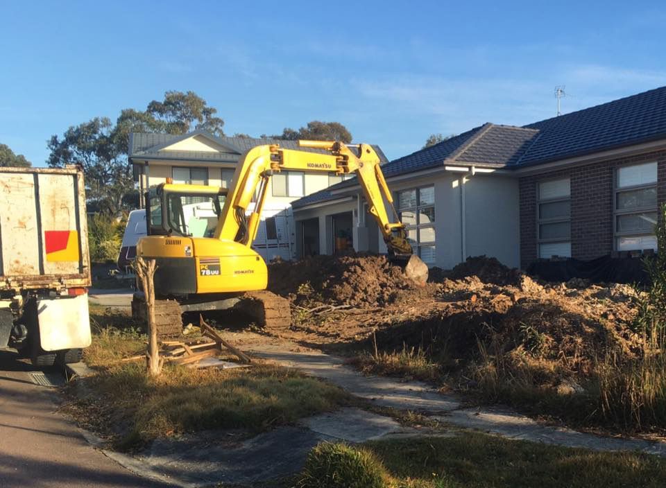 A Yellow Excavator Is Digging The Front Yard — Atholyn Earthmovers in Wyee, NSW