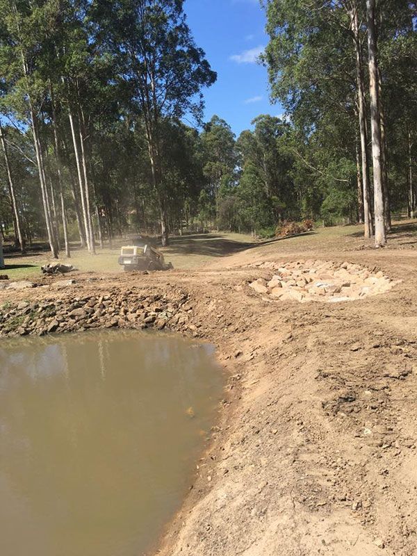 Excavator is driving down to septic tank construction — Atholyn Earthmovers in Cessnock, NSW