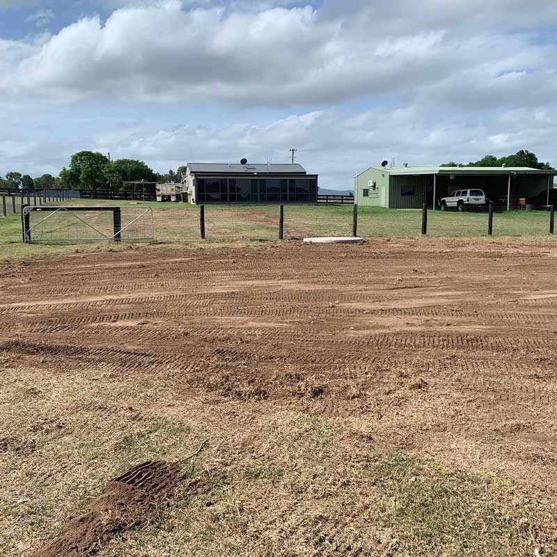 A Large Dirt Field With A House In The Background — Atholyn Earthmovers in Wyee, NSW