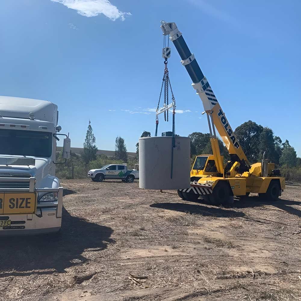 A yellow Earthmover Equipment Lifting The Septic Tank — Atholyn Earthmovers in Wyee, NSW