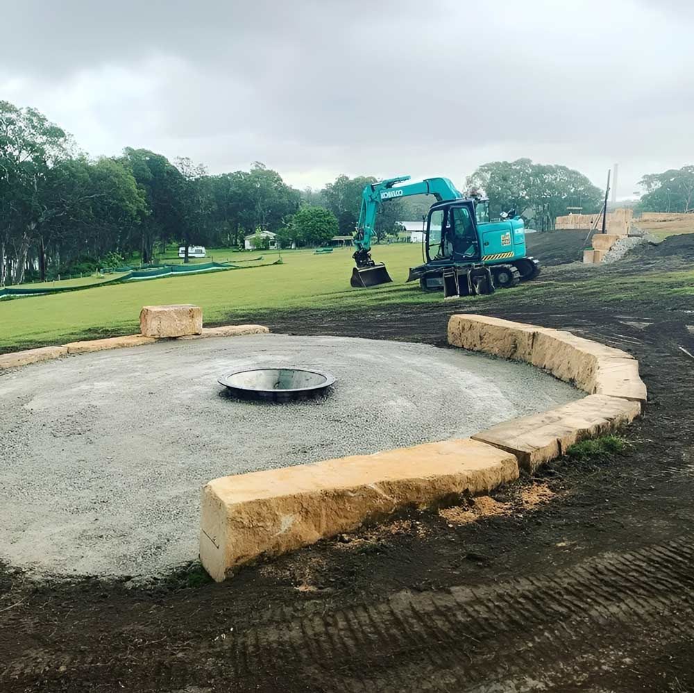 A Blue Excavator Is Working On A Construction Site — Atholyn Earthmovers in Wyee, NSW