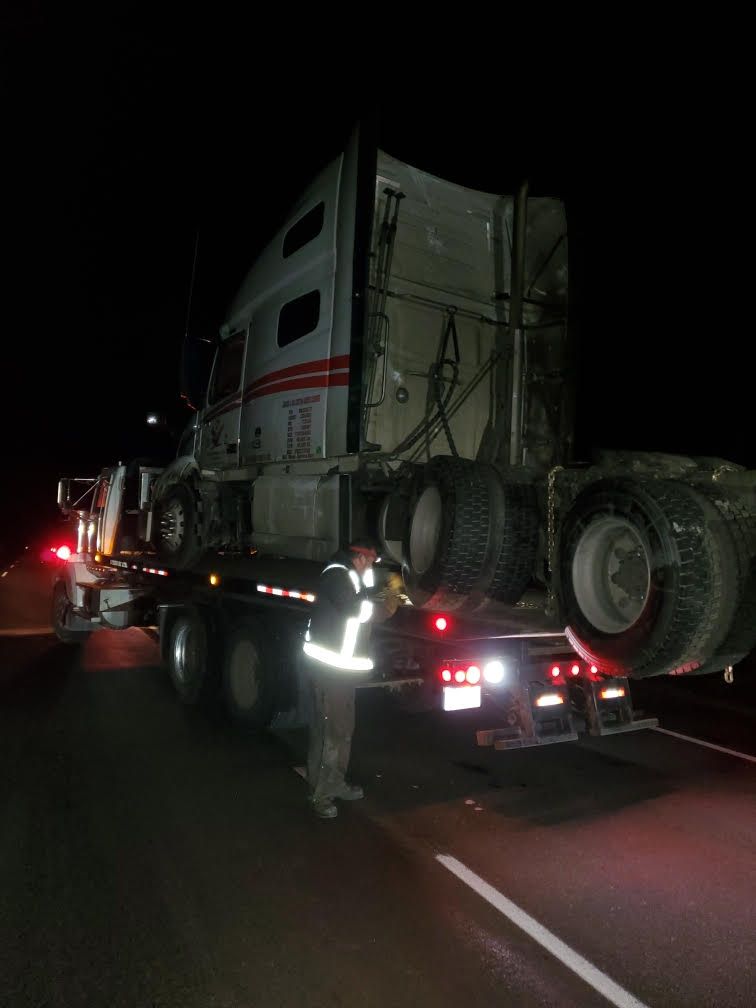 Truck loaded onto the back of a heavy rescue wrecker in Kamloops late at night
