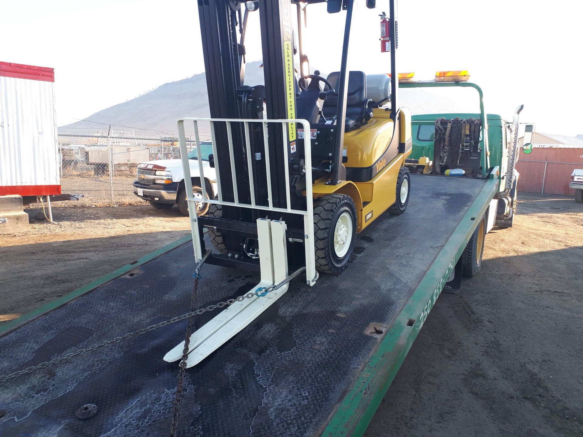 a forklift loaded up onto flatbed of a Git-Er-Done Towing truck