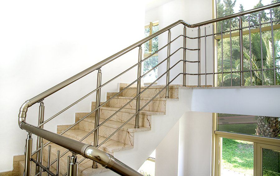 a marbled type of stairs with stainless handrails