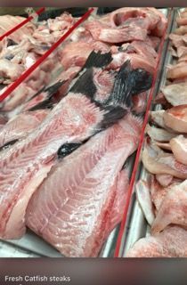 A tray of fresh catfish steaks in a store.