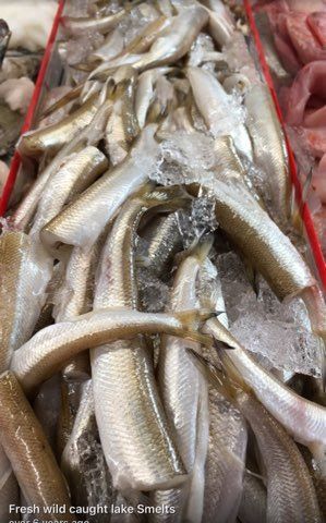 A pile of fish sitting on top of ice in a market.