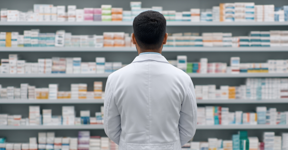 A healthcare provider in blue uniform comforts an older person, both sitting on a sofa.