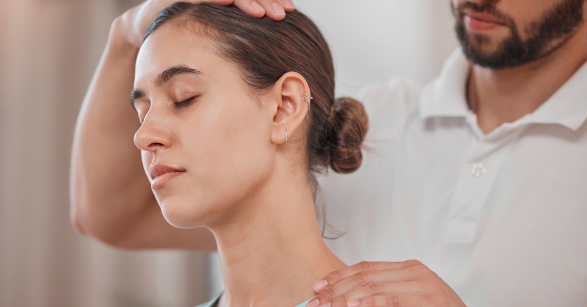A person getting a neck adjustment by a health professional; both are in a brightly lit setting.