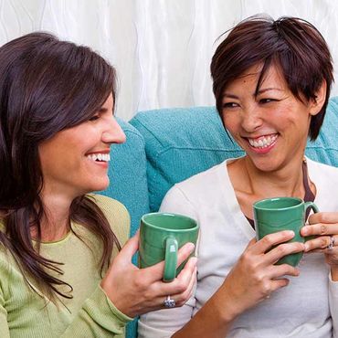 women laughing together over coffee