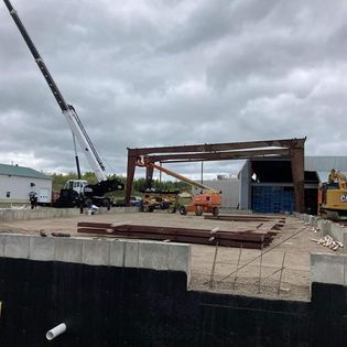 Une grande grue est utilisée pour soulever une grande structure métallique.