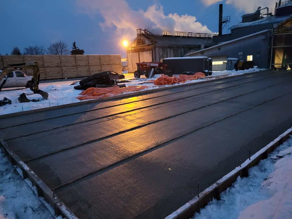 Un toit est en train d'être construit dans la neige devant un bâtiment.