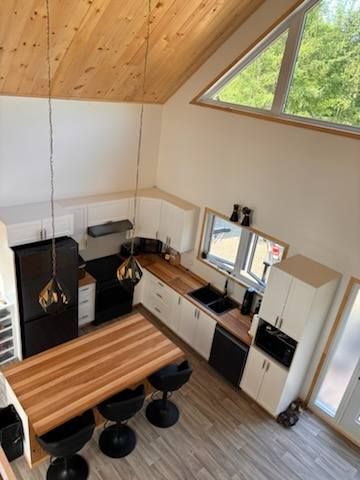 Une vue aérienne d'une cuisine avec une table et des chaises en bois.