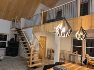 Un salon avec un escalier en bois menant au deuxième étage.