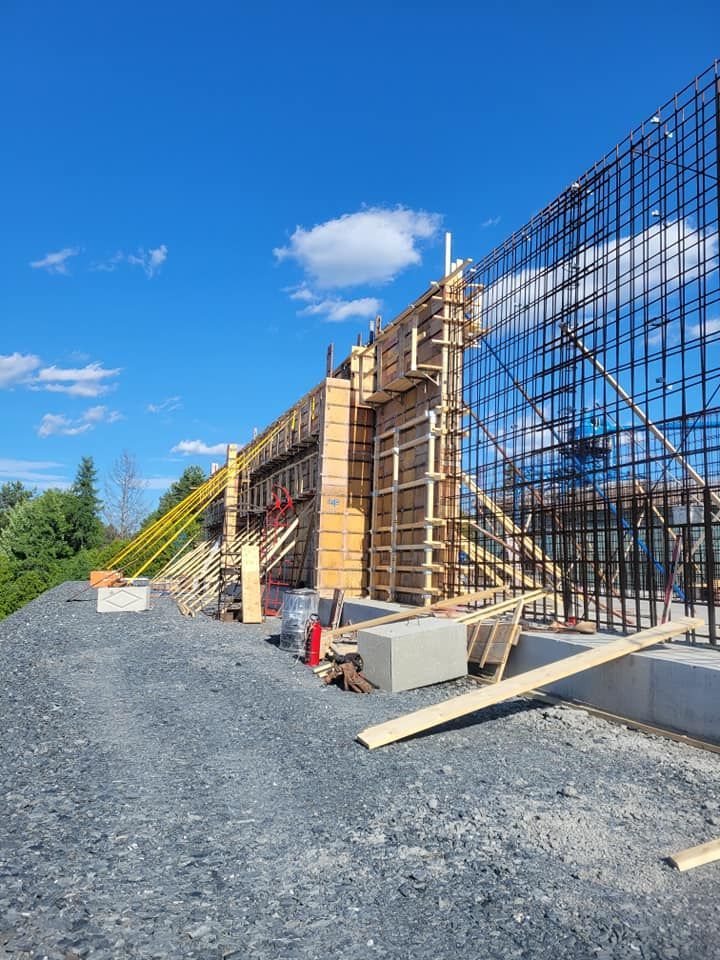Un grand mur est en train d'être construit sur un tas de gravier.