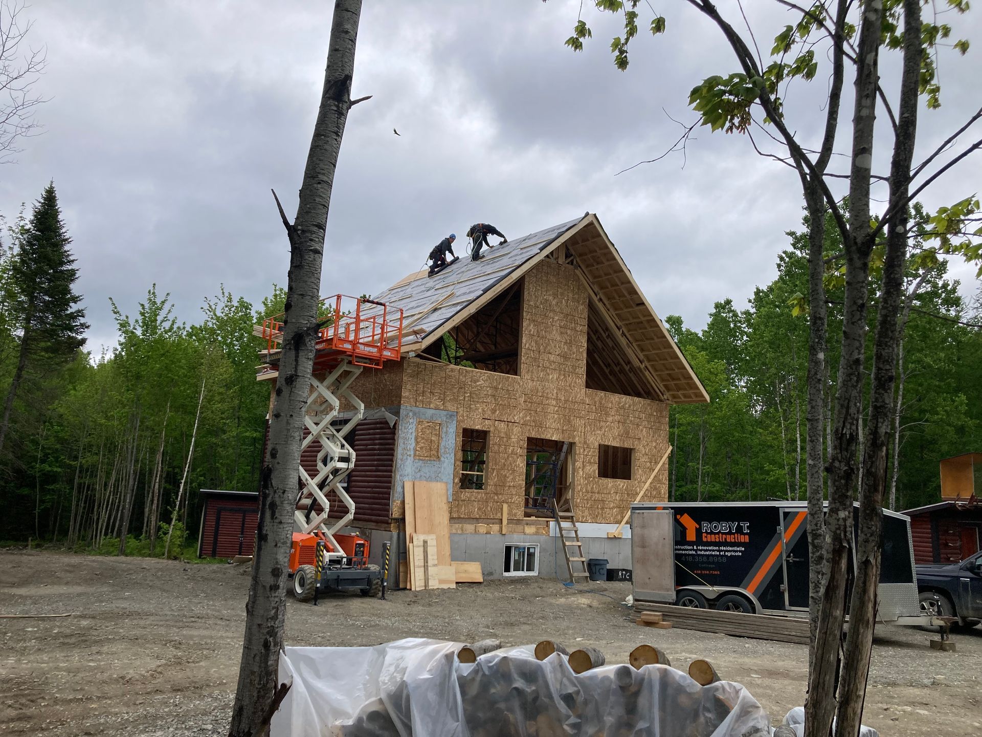 Une maison est en construction au milieu d'une forêt.