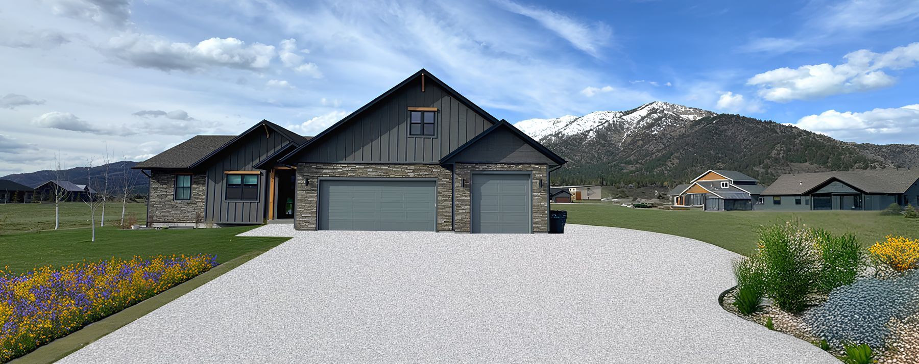 A modern home with dark siding and stone accents, a light gravel driveway, and a snowy mountain in the background.