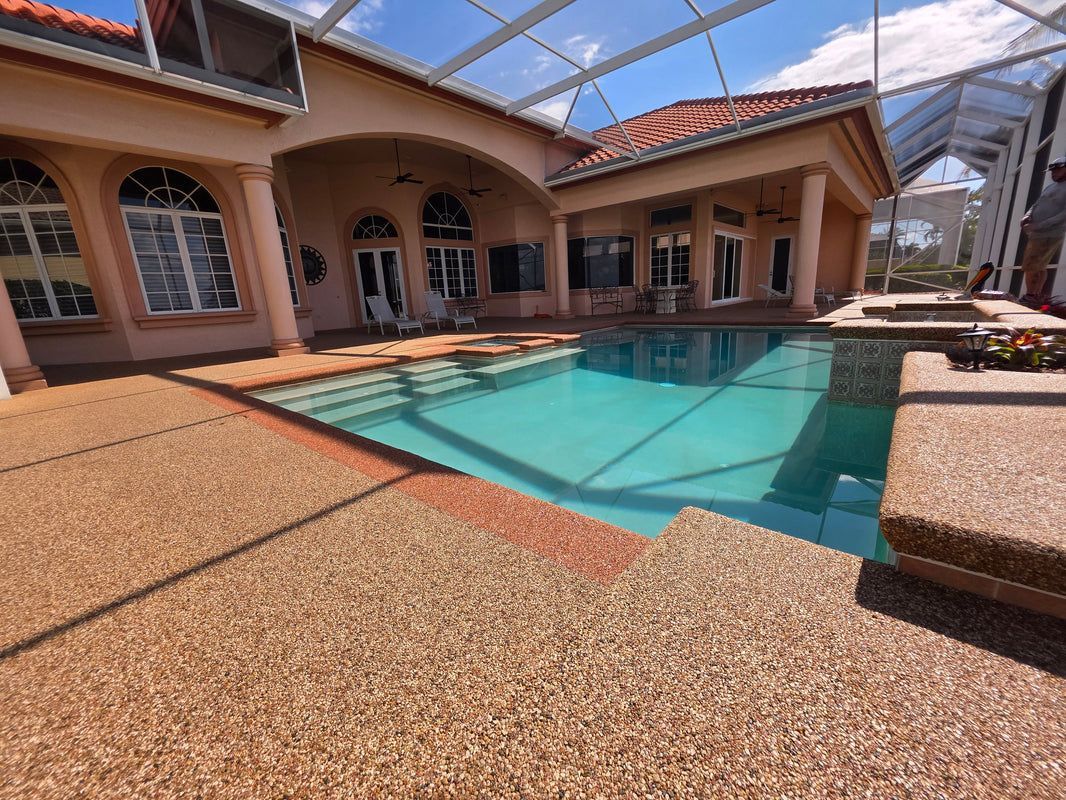 Courtyard patio with turquoise pool beside a tan house under a screened enclosure