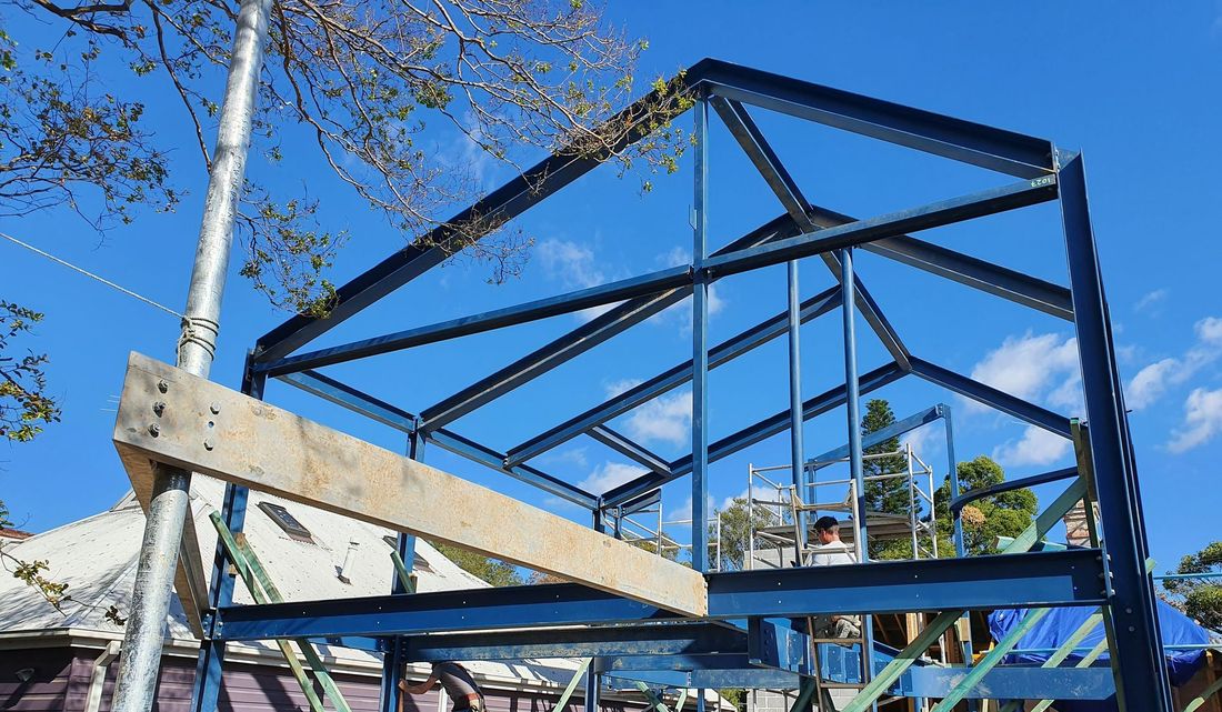 A building under construction with a blue sky in the background.