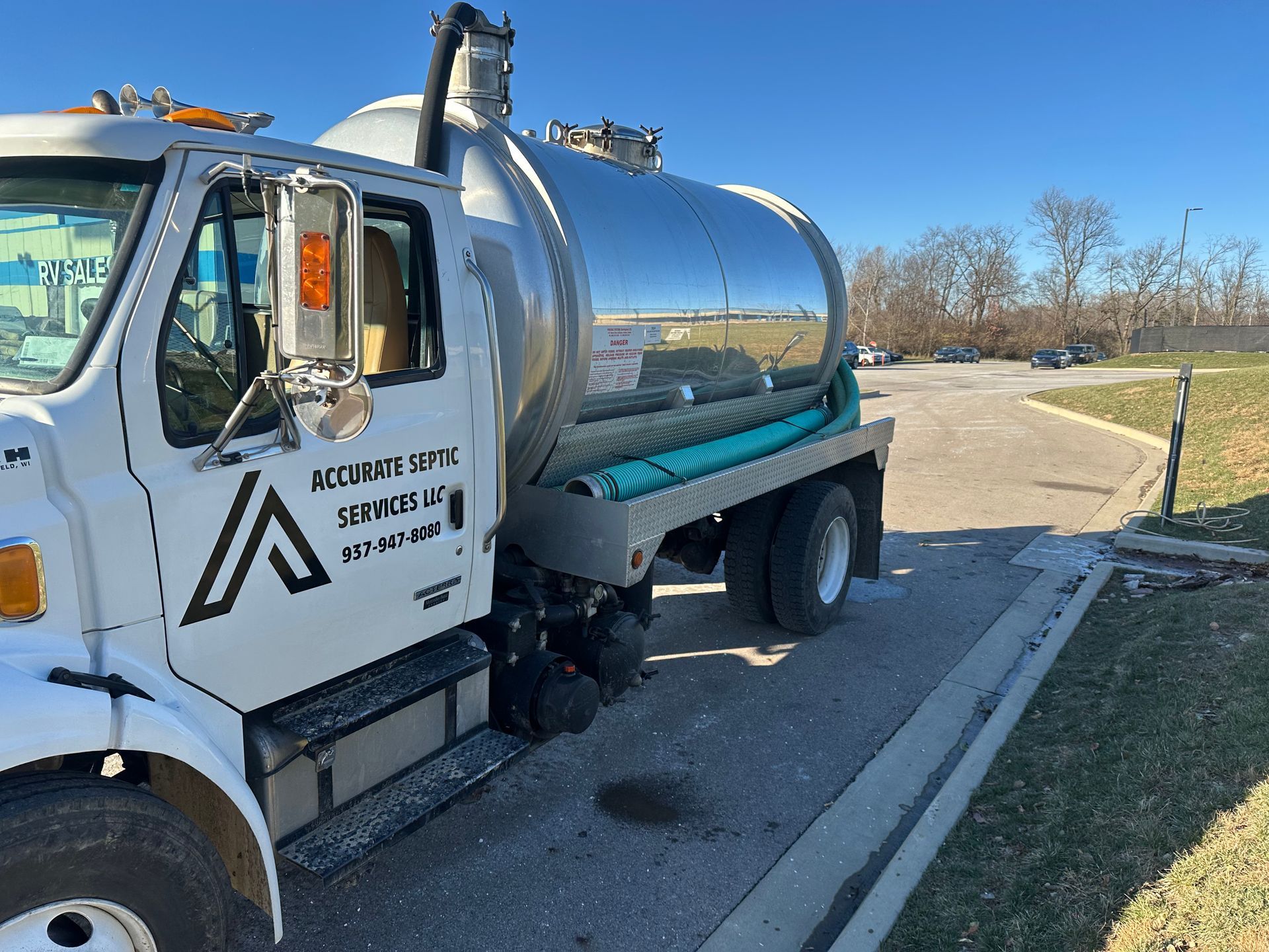 A vacuum truck is parked on the side of the road.
